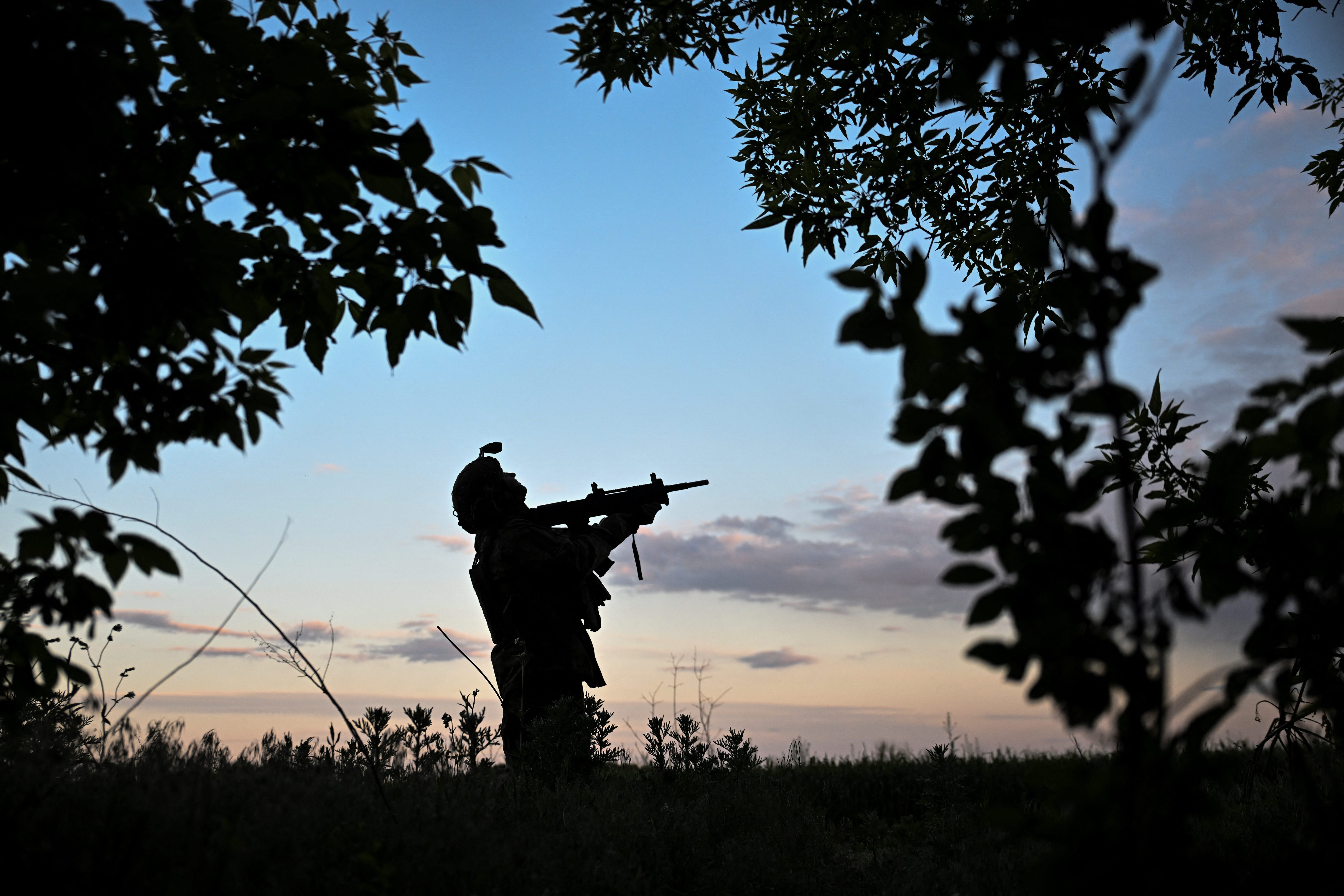 A serviceman of the 141st Separate Mechanized Brigade of the Ukrainian Armed Forces observes the sky for Russian FPV drones at a position in the Donetsk region.