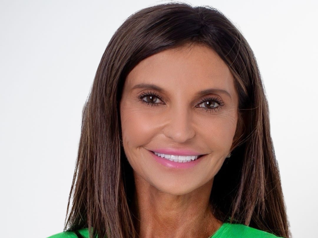 DraftKings executive Lori Kalani smiles in a green sweater in front of a white backdrop.