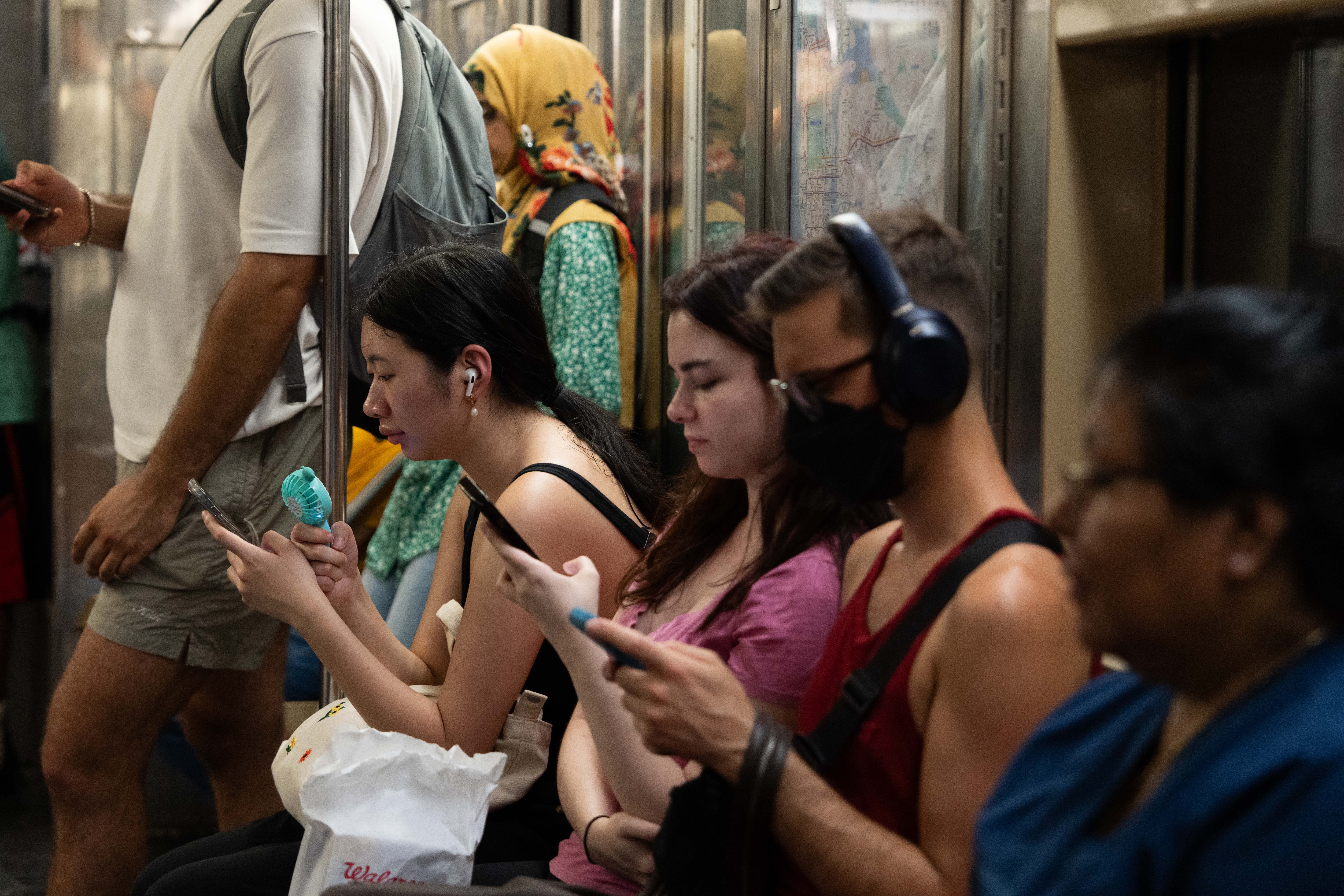 Woman fans herself on subway