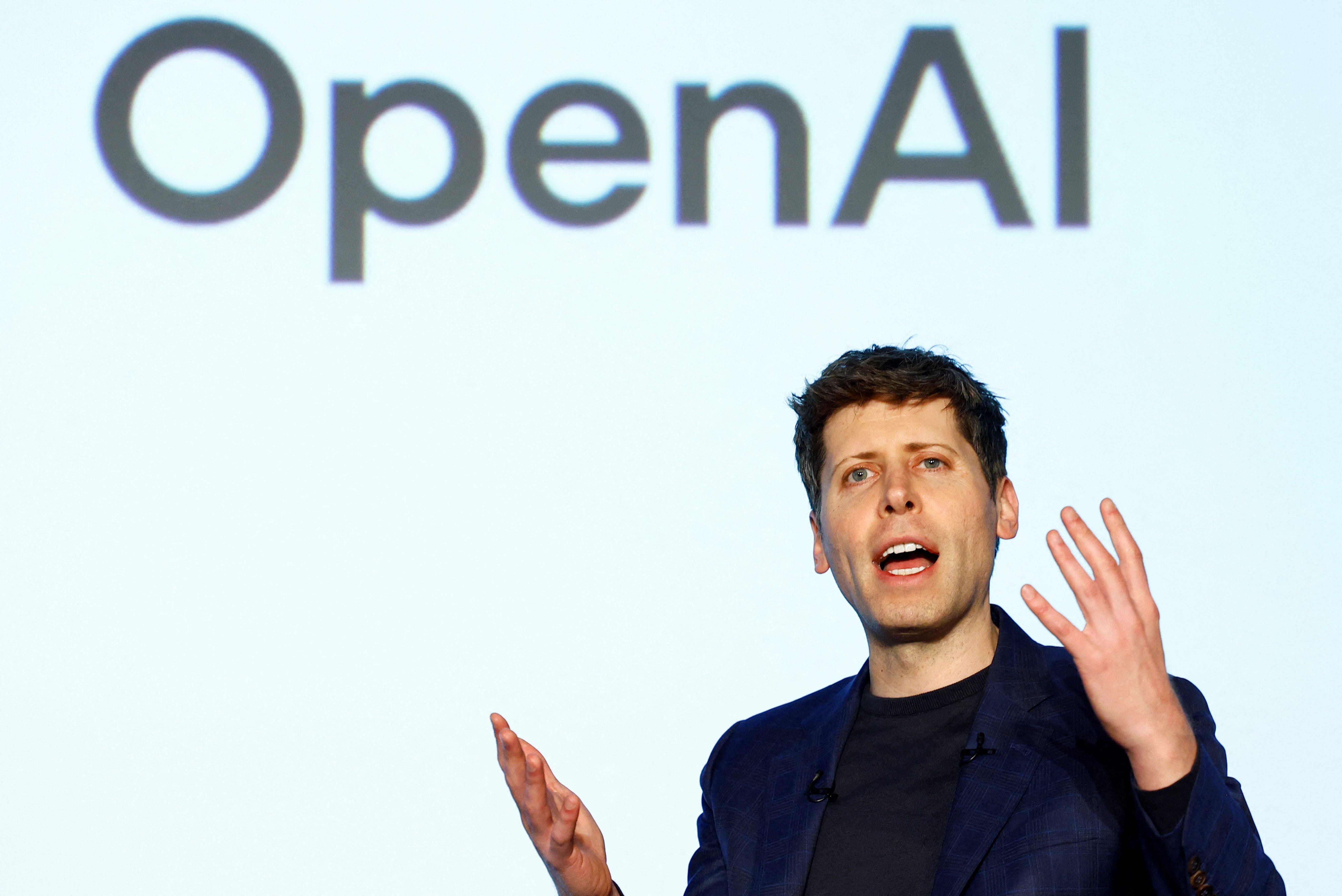 Sam Altman in front of an OpenAI sign