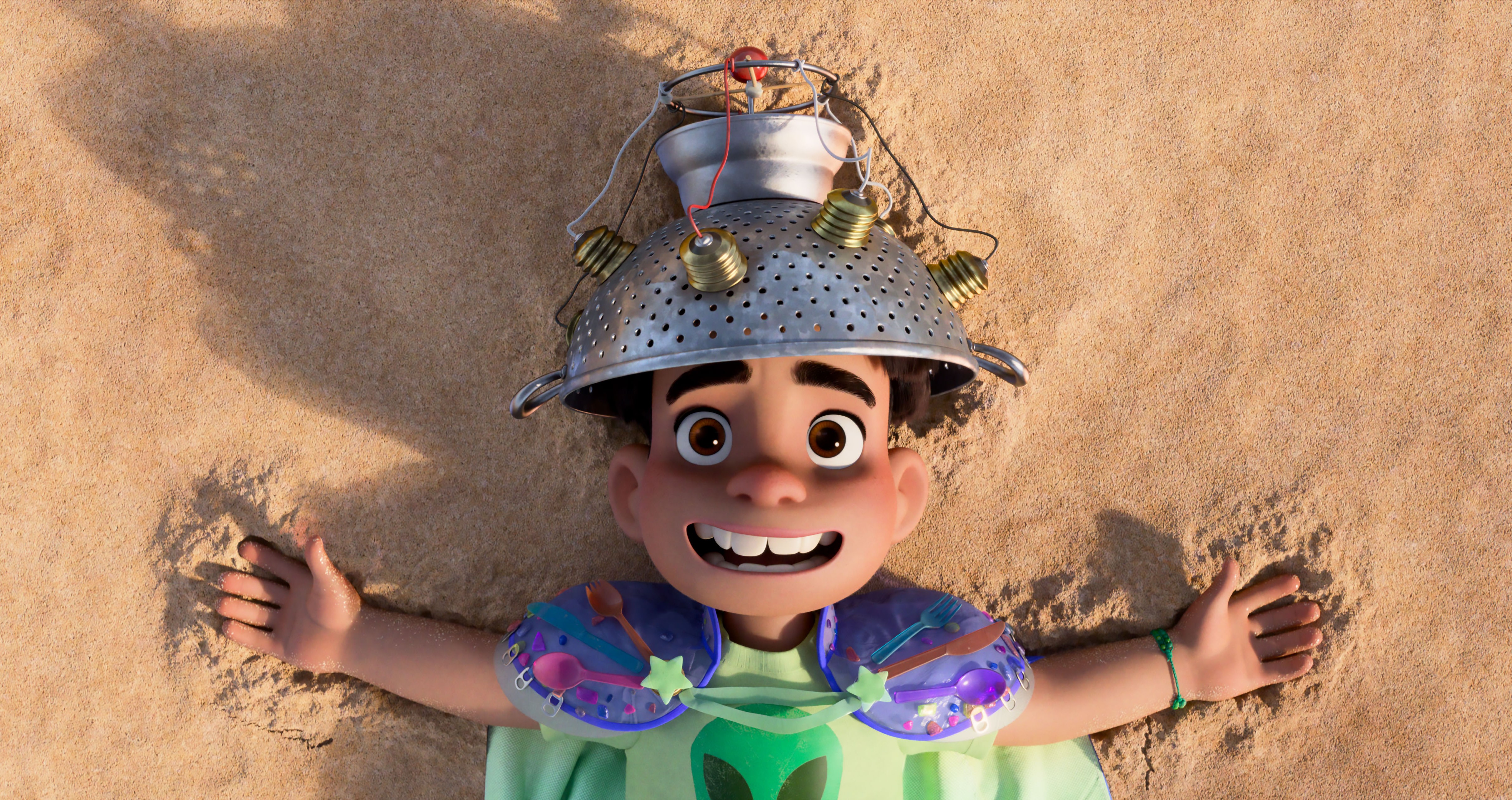 Elio lays on the beach with a helmet made out of a collander