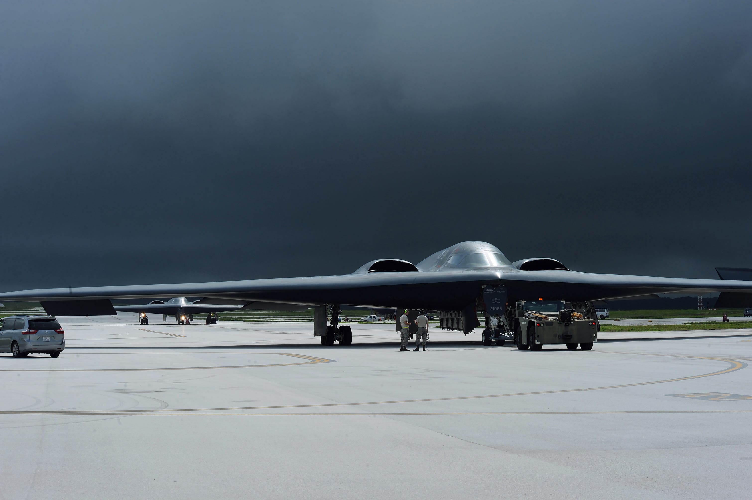 Multiple B-2 Spirits on a flight line on a stormy day.