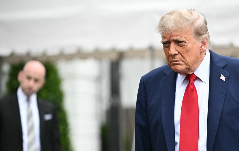 Stephen Miller (left) watches President Donald Trump speak to journalists as he makes his way to board Marine One before departing from the South Lawn of the White House