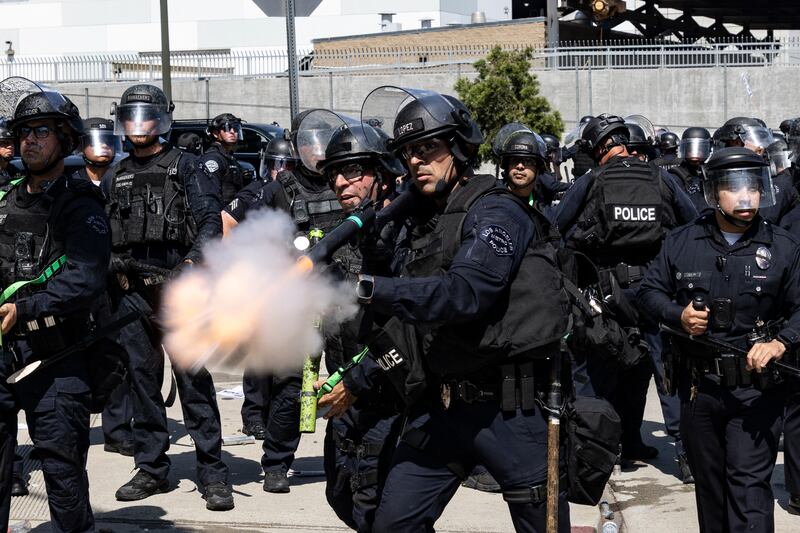 Law enforcement fire less-lethal munitions at protesters during clashes outside the federal building in Los Angeles, California, on June 8, 2025, following federal immigration operations.