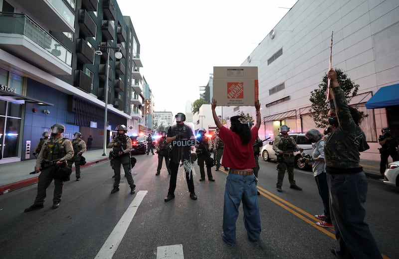 Demonstrators hold up signs in a protest against federal immigration, in downtown Los Angeles, California, U.S. June 9, 2025.