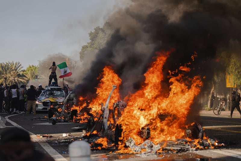 Several cars burn on North Los Angeles street during clashes between protesters and police on June 8, 2025 in Downtown Los Angeles, California.