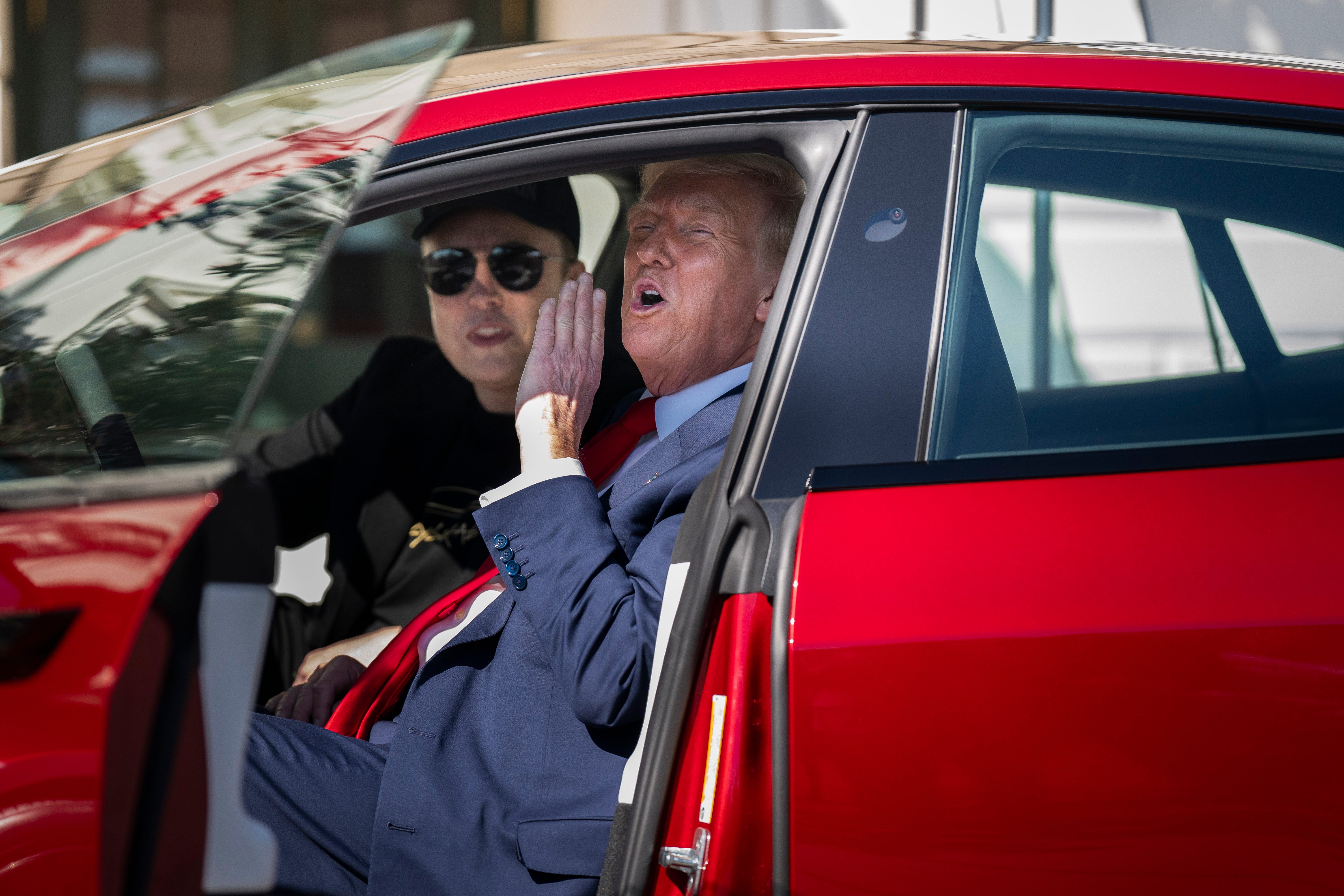Elon Musk and Donald Trump in a Tesla outside the White House