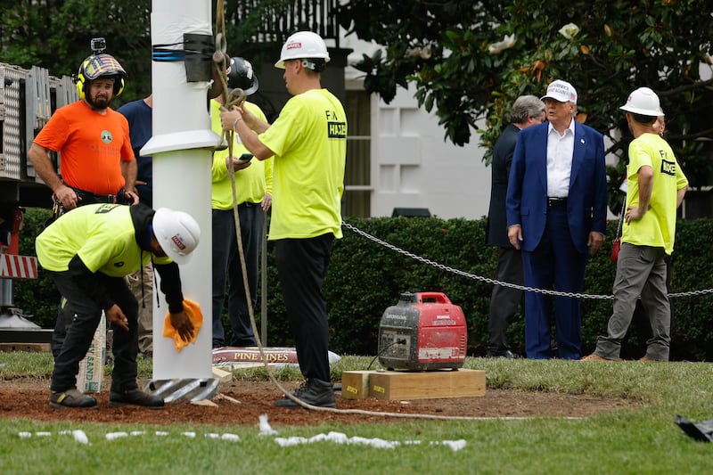 WASHINGTON, DC - JUNE 18: U.S. President Donald Trump talks with workers as they install a new flag pole on the South Lawn of the White House on June 18, 2025 in Washington, DC. Trump said that he personally paid for the pole and another just like it on the North Lawn and their installations. (Photo by Chip Somodevilla/Getty Images)