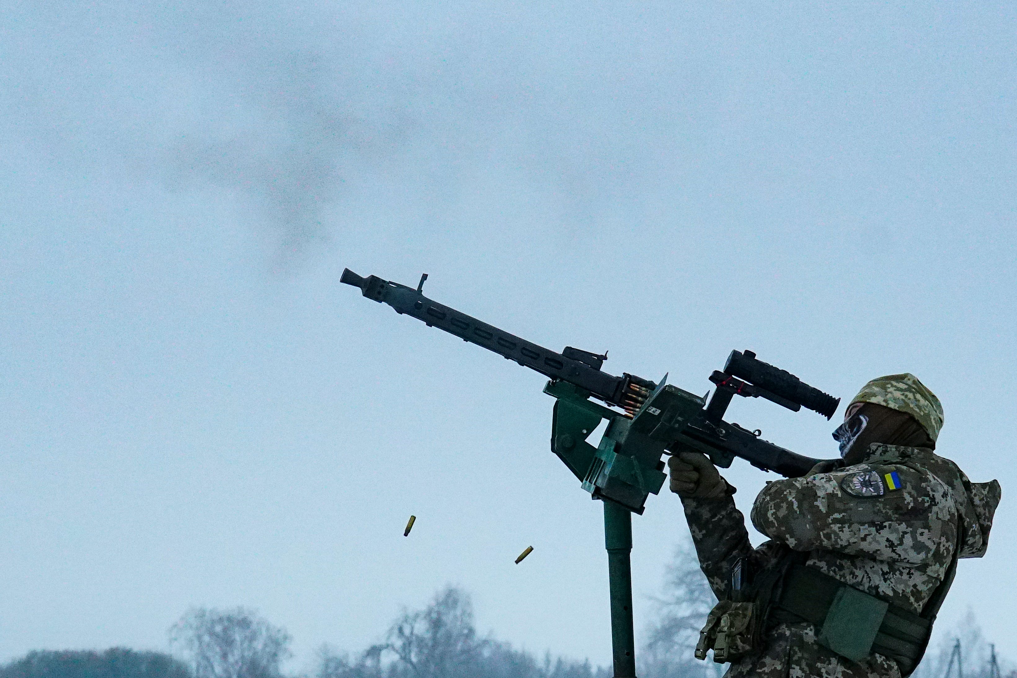 A Ukrainian serviceman of the mobile air defense unit fires a machine gun at Russian drones during a patrol.
