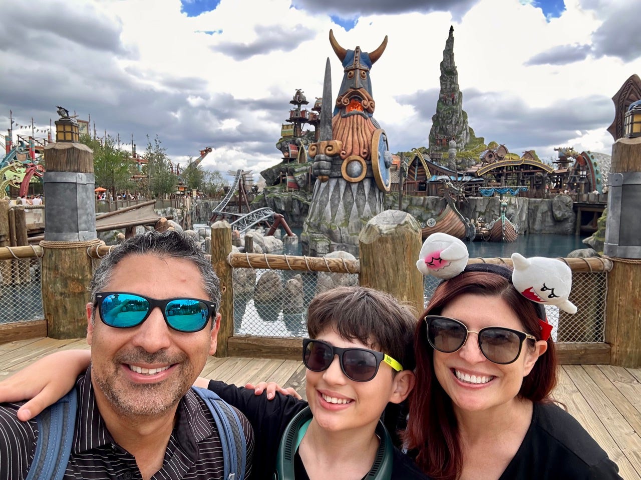 Author Amanda Adler smiling with her son and husband at Isle of Berk in Epic Universe