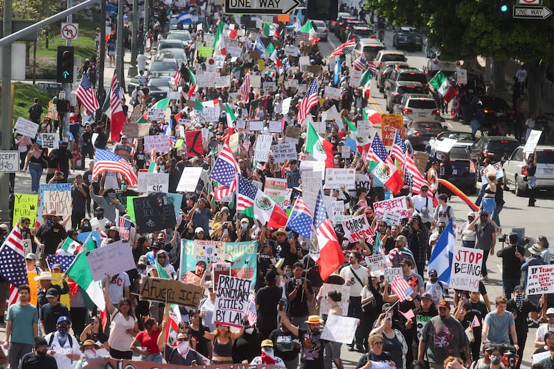 Demonstrators holding signs and flags participate in a 