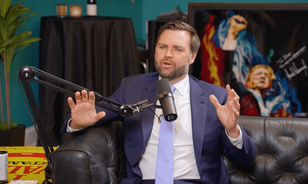 Man in suit speaking into a microphone.