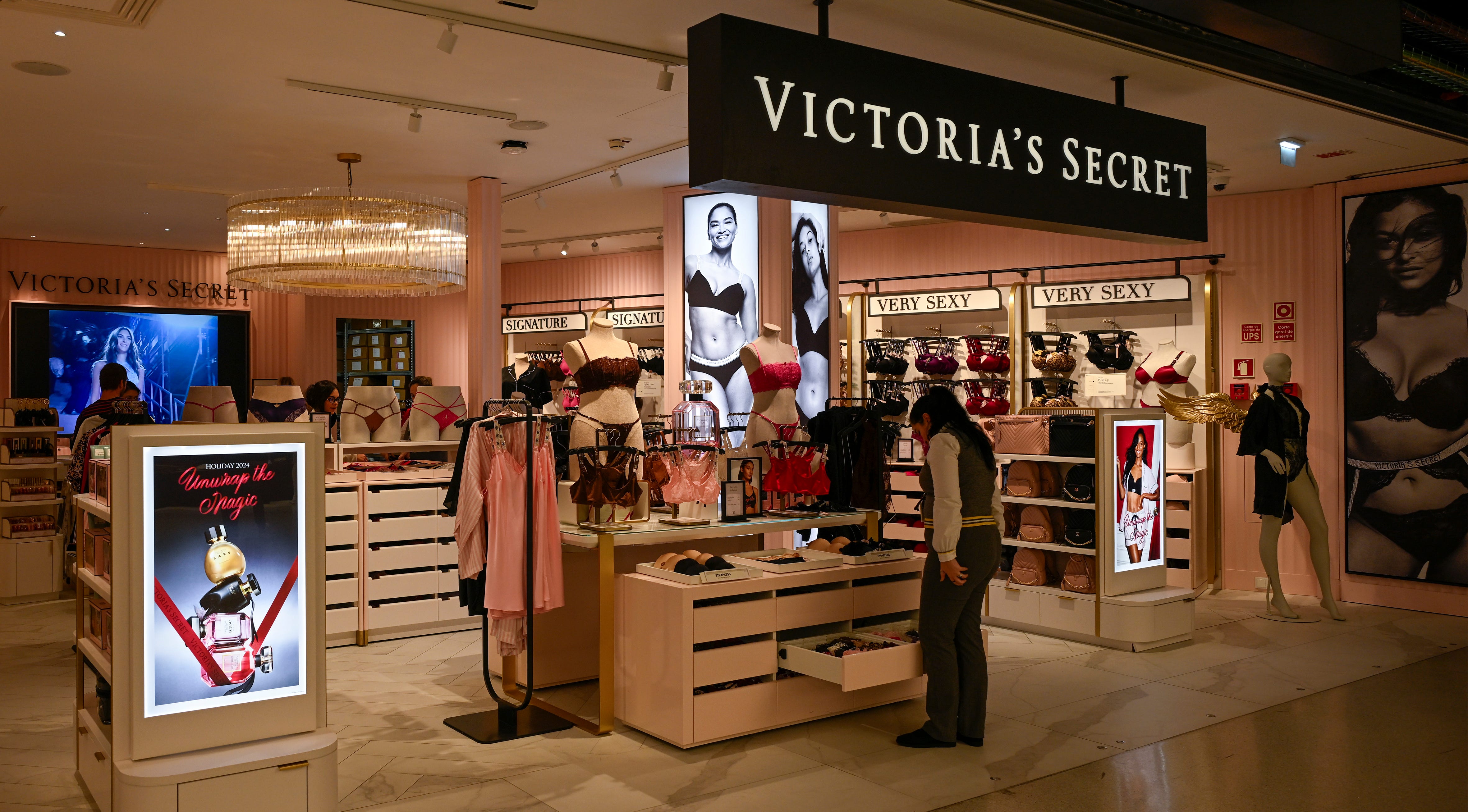 A woman looks at a selection of bras on display as a black-and-white