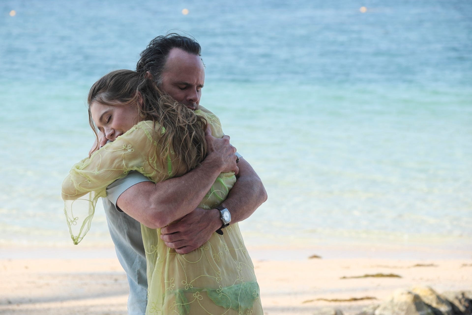 A man and a woman embrace on a beach