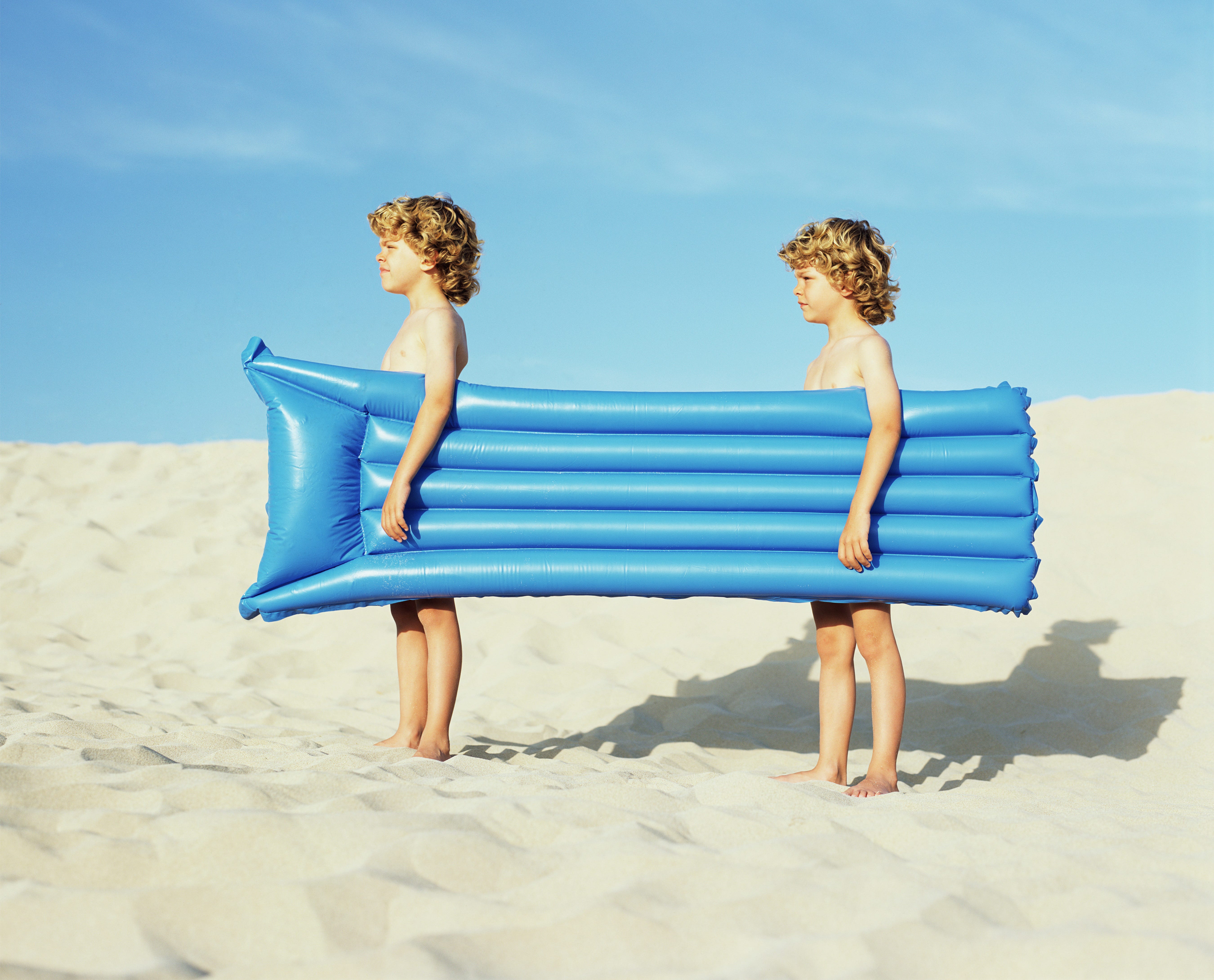 Twin boys carrying an inflatable