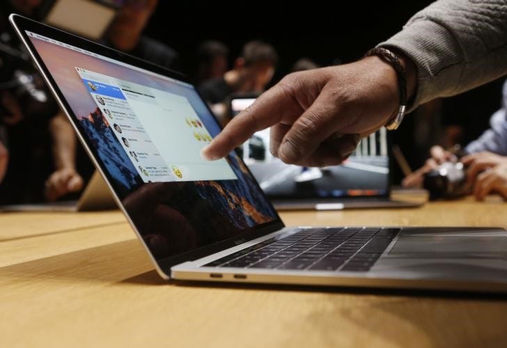 FILE PHOTO: A guest points to a new MacBook Pro during an Apple media event in Cupertino, California, U.S. October 27, 2016. REUTERS/Beck Diefenbach/File Photo
