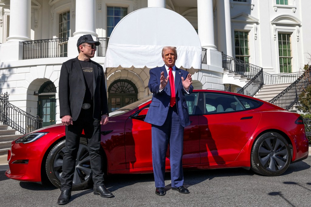 President Donald Trump talks to the media next to Tesla CEO Elon Musk, with a Tesla car in the background, at the White House in Washington, D.C., U.S., March 11, 2025.