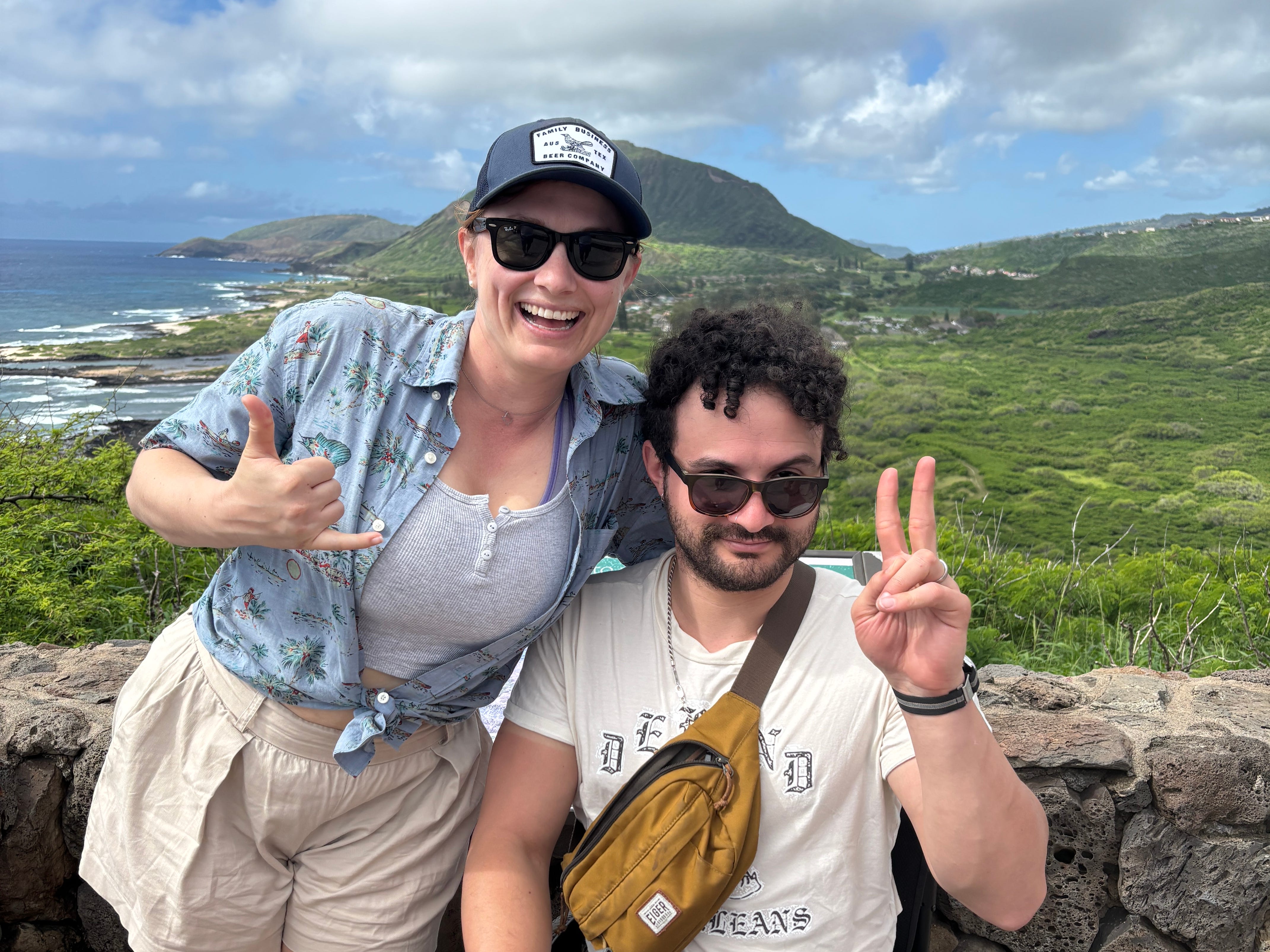 The author and her husband at a vista overlooking a mountain and ocean cliffside.