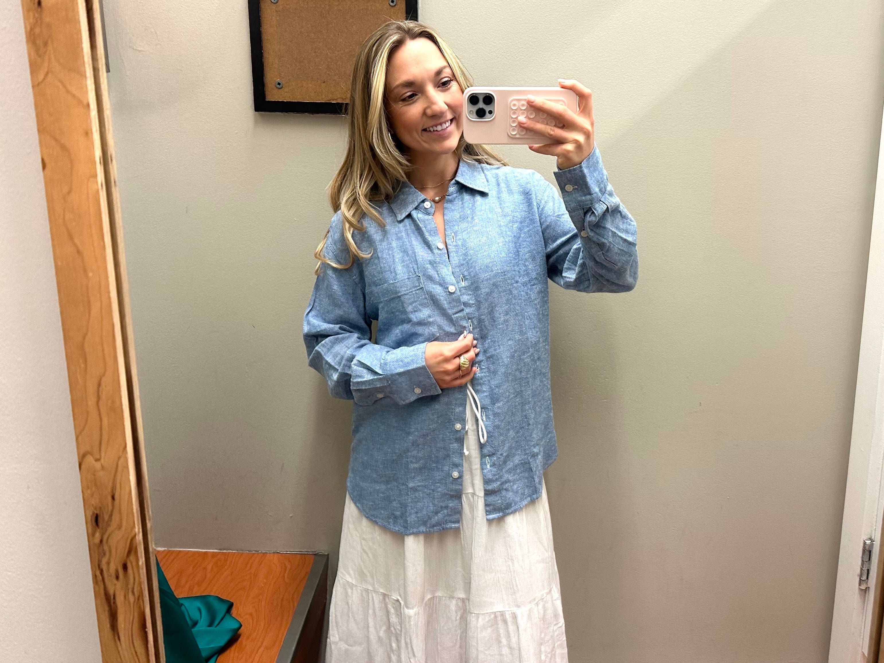 Chloe wears a blue button-up shirt over a long white flowy skirt in a Banana Republic fitting room.