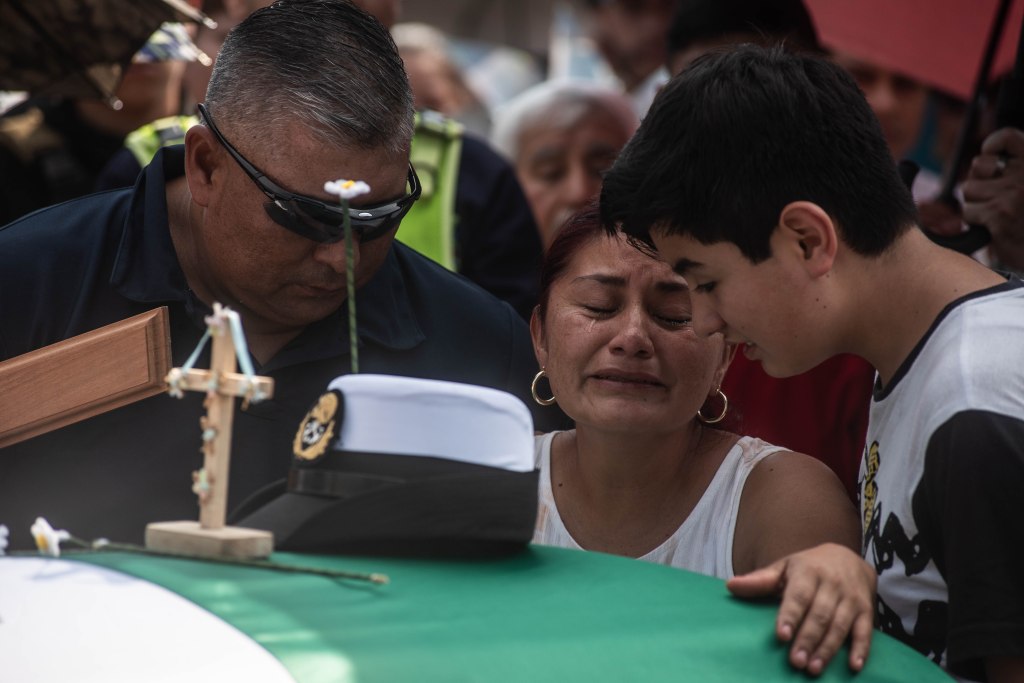 A grieving mother and son at a funeral.