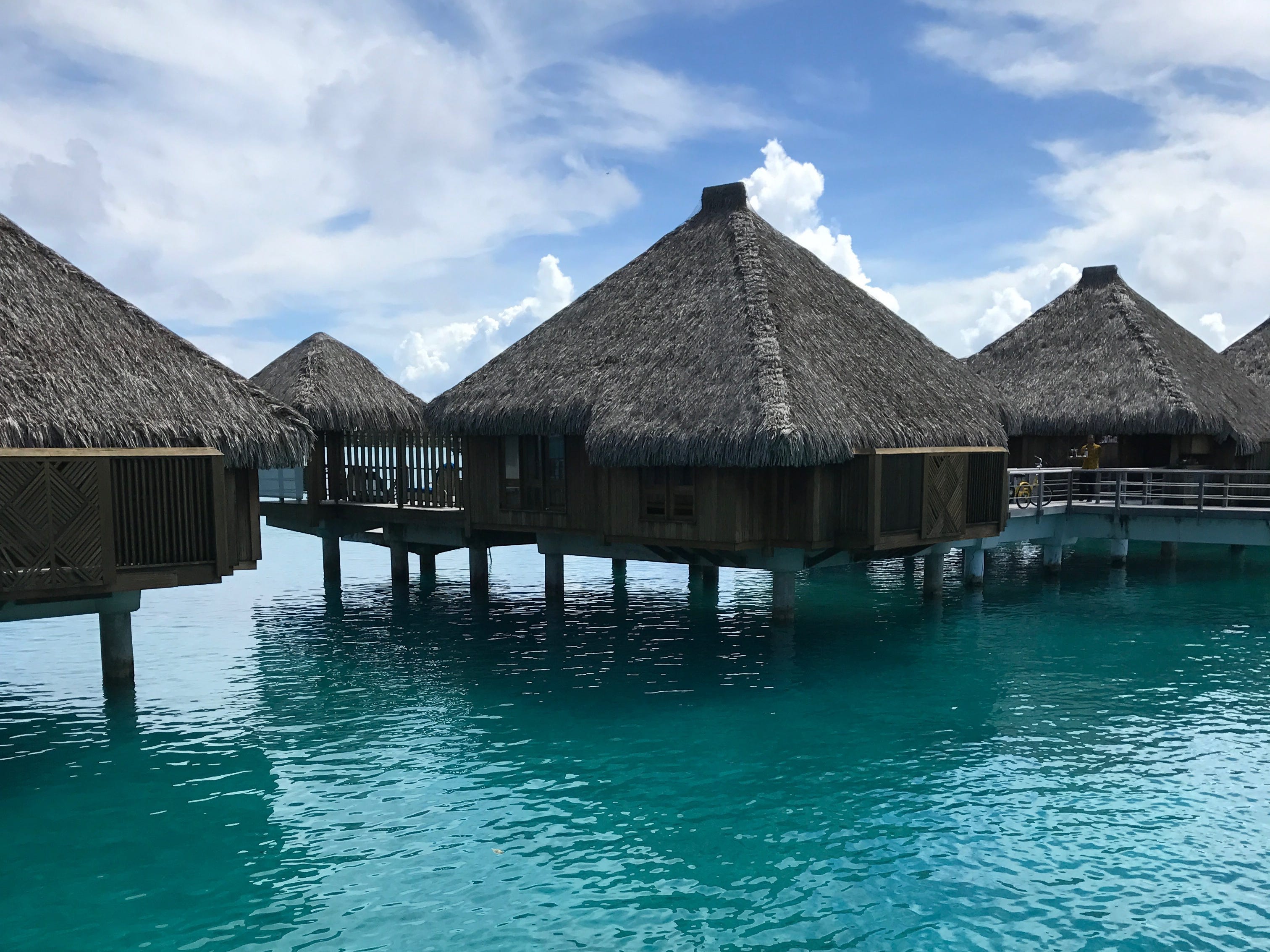 Overwater bungalow above blue waters