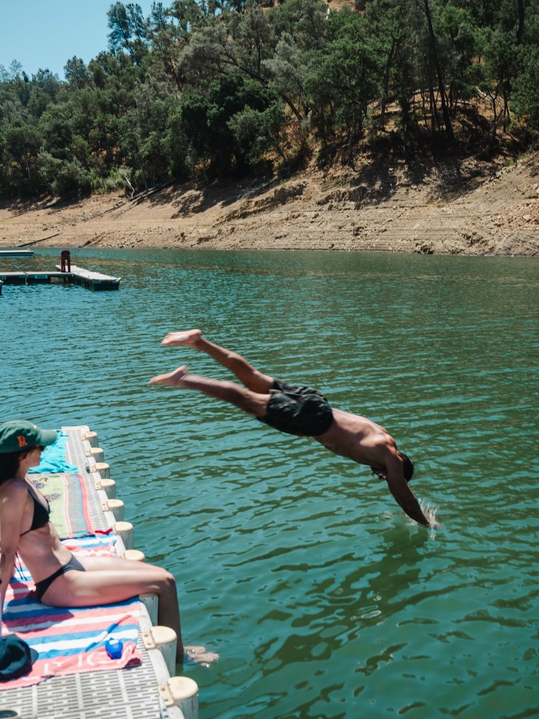 Zac Efron dives into a lake.