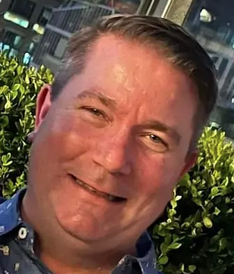Headshot of a smiling man.