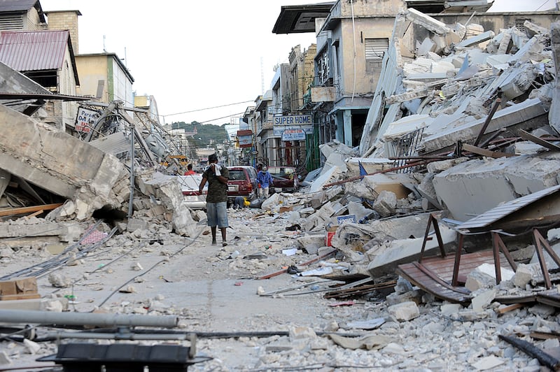A man covers his face as he walks amid the rubble of a destroyed building in Port-au-Prince on January 14, 2010, following the devastating earthquake that rocked Haiti on January 12.