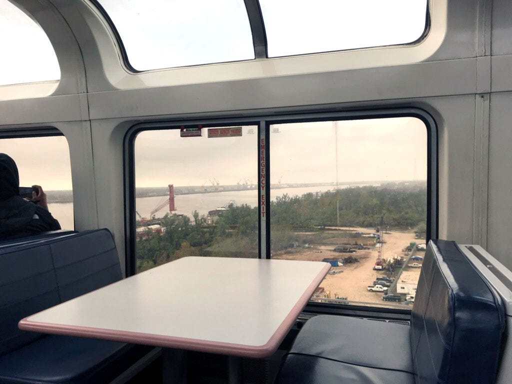 A booth on a train with large windows.