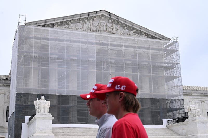 Two mean wearing "Make America Great Again Hats" walk by the Supreme Court in Washington, DC. on June 27, 2025.
