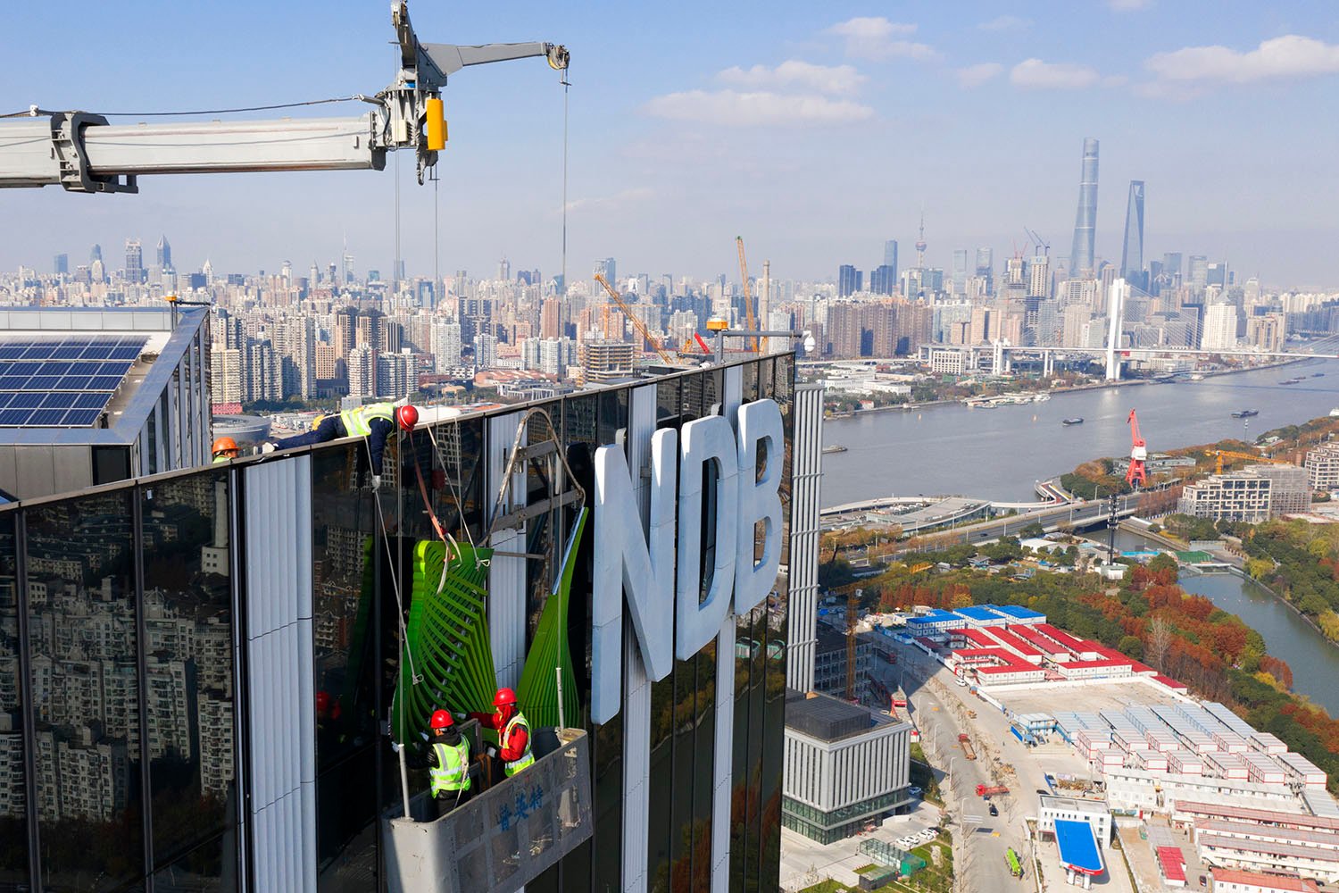 Construction workers install the logo of the New Development Bank in Shanghai.