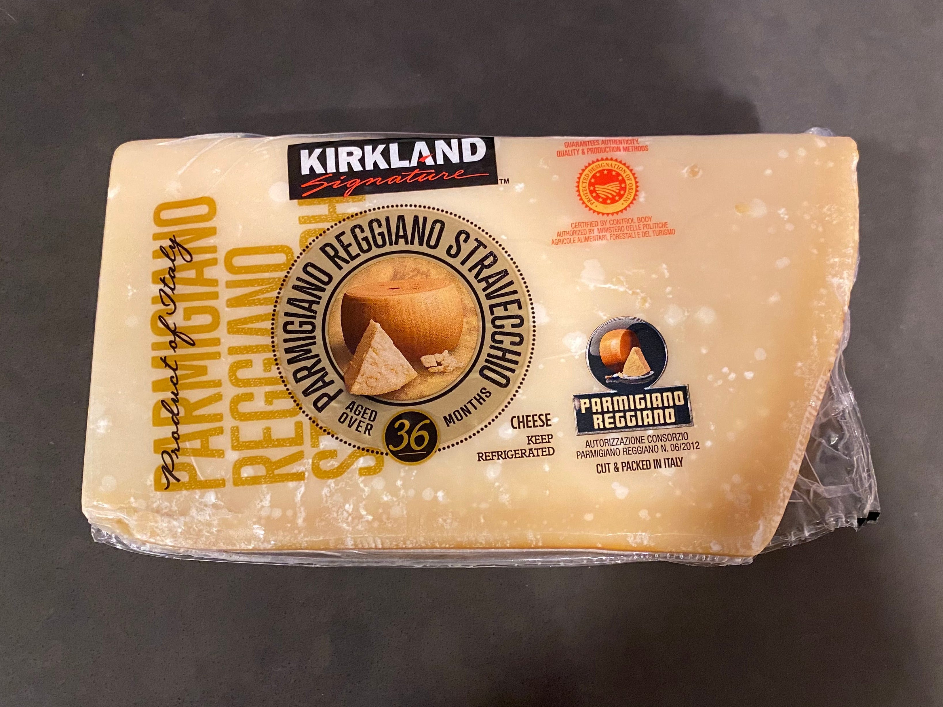 chunk of packaged kirkland parmigiano reggiano on black countertop