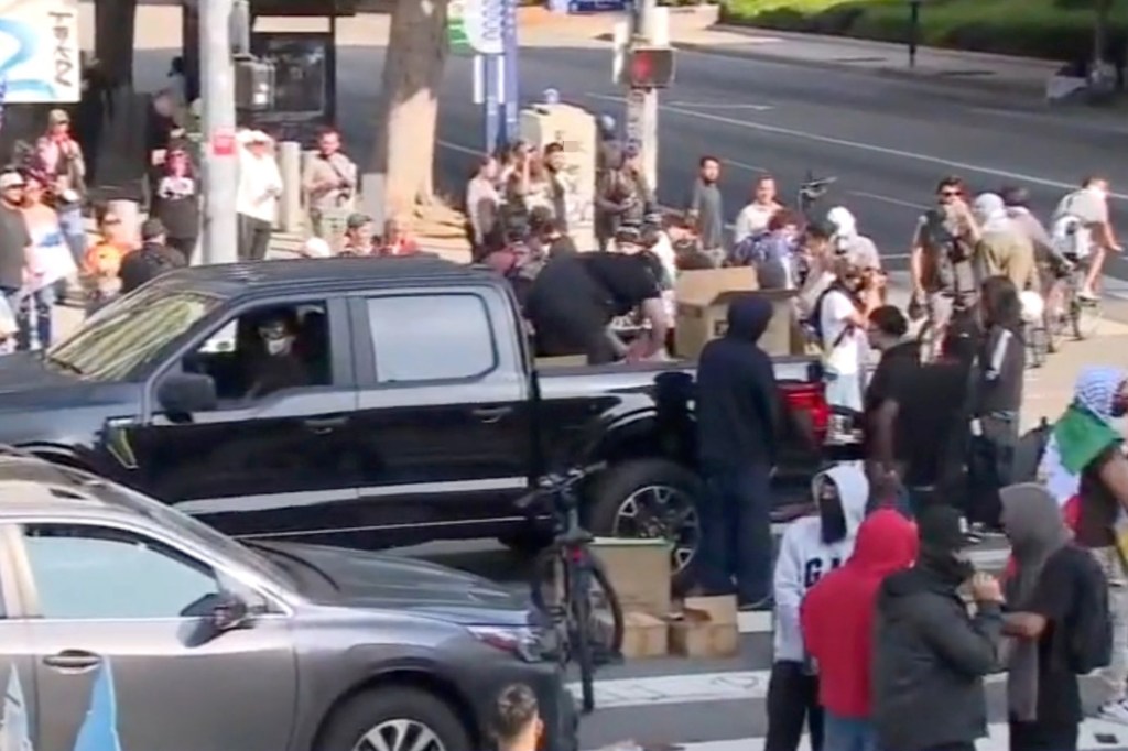 Potential outside agitators are seen handing out PPE face shields and water to protestors in Los Angeles .