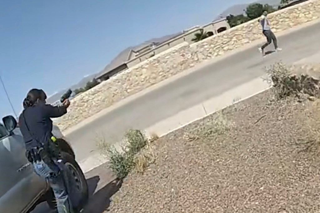Police officer aiming a gun at a fleeing suspect.