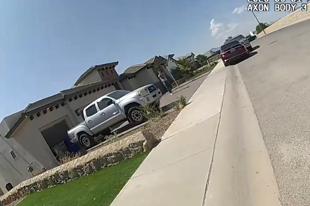 Police body camera footage of a silver truck parked in a residential driveway.