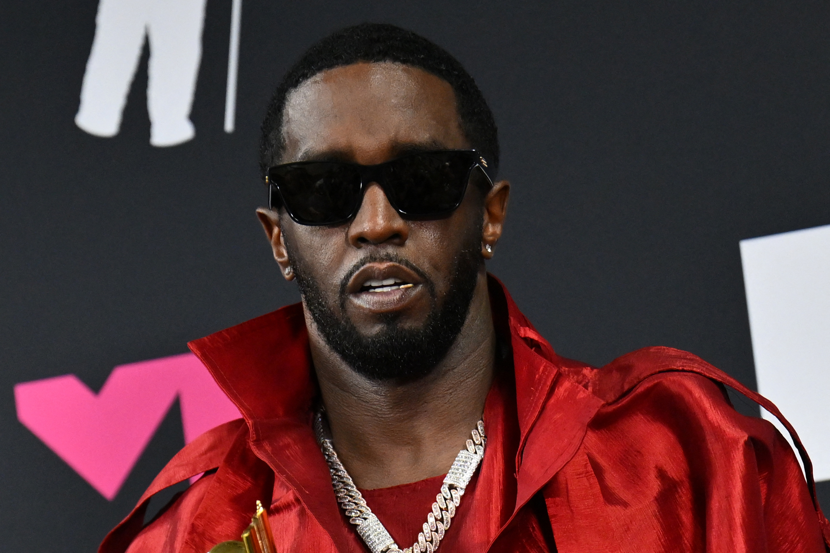 Sean Combs in a red jacket and gold jewelry. 