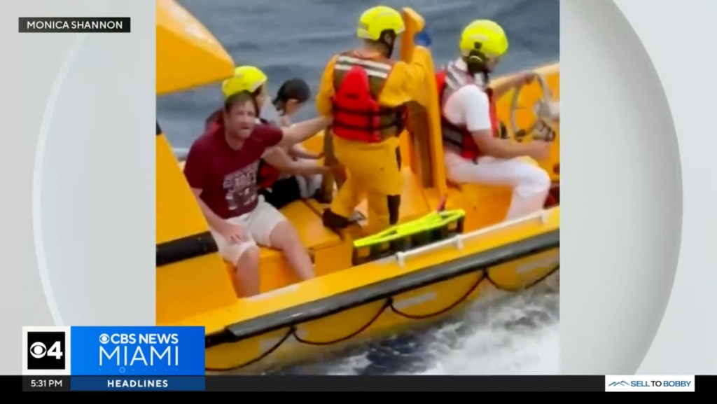 Rescue boat assisting a man and child at sea.
