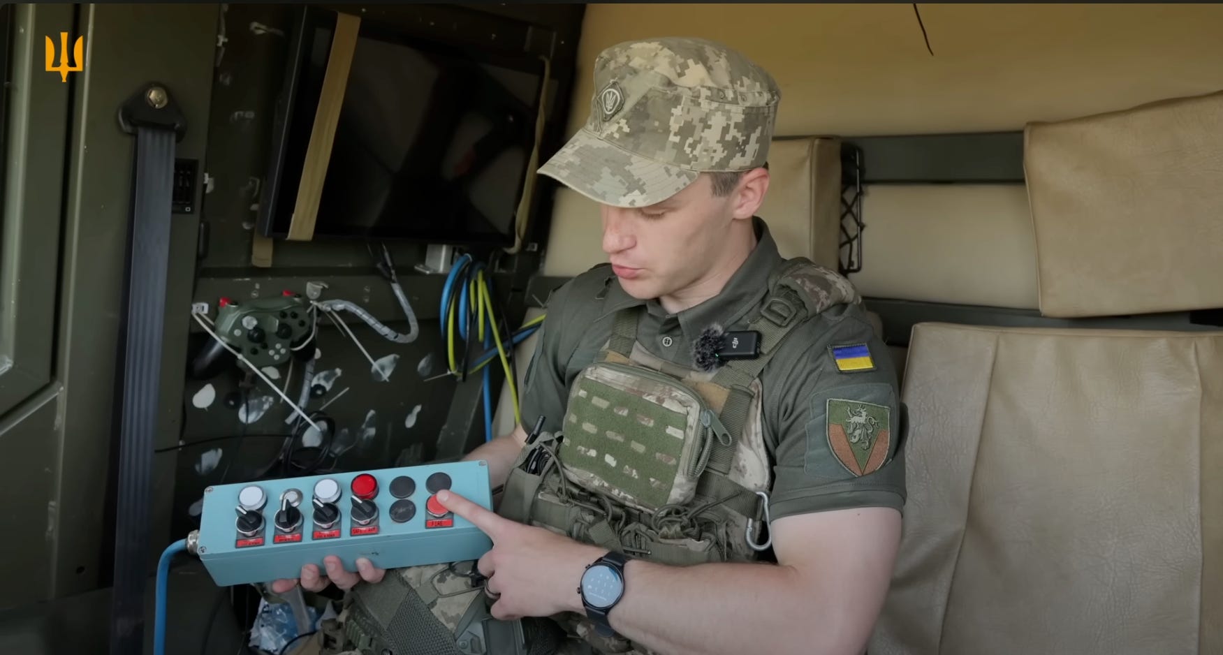 A Ukrainian operator holds a switchboard with five switches and a launch button.