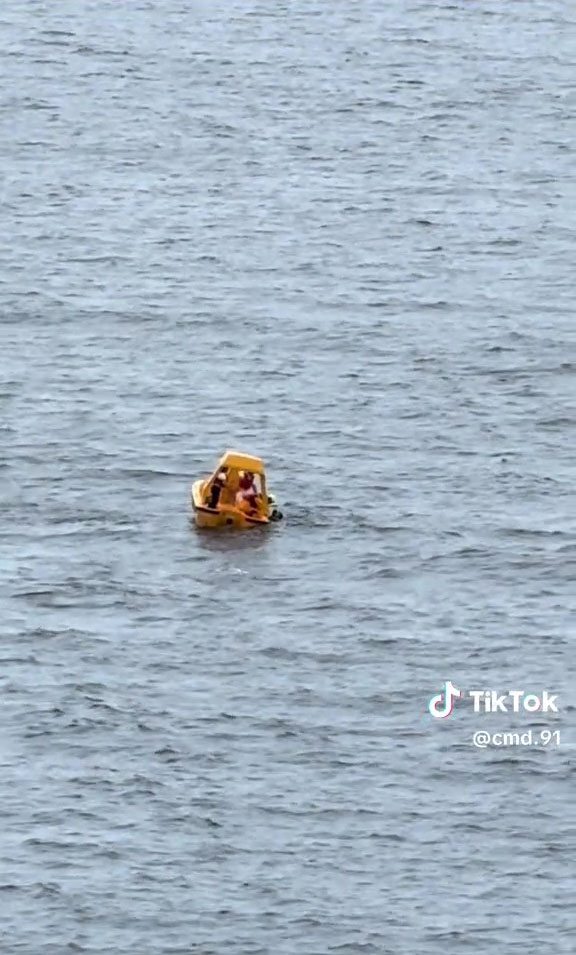 A small yellow boat in the ocean.
