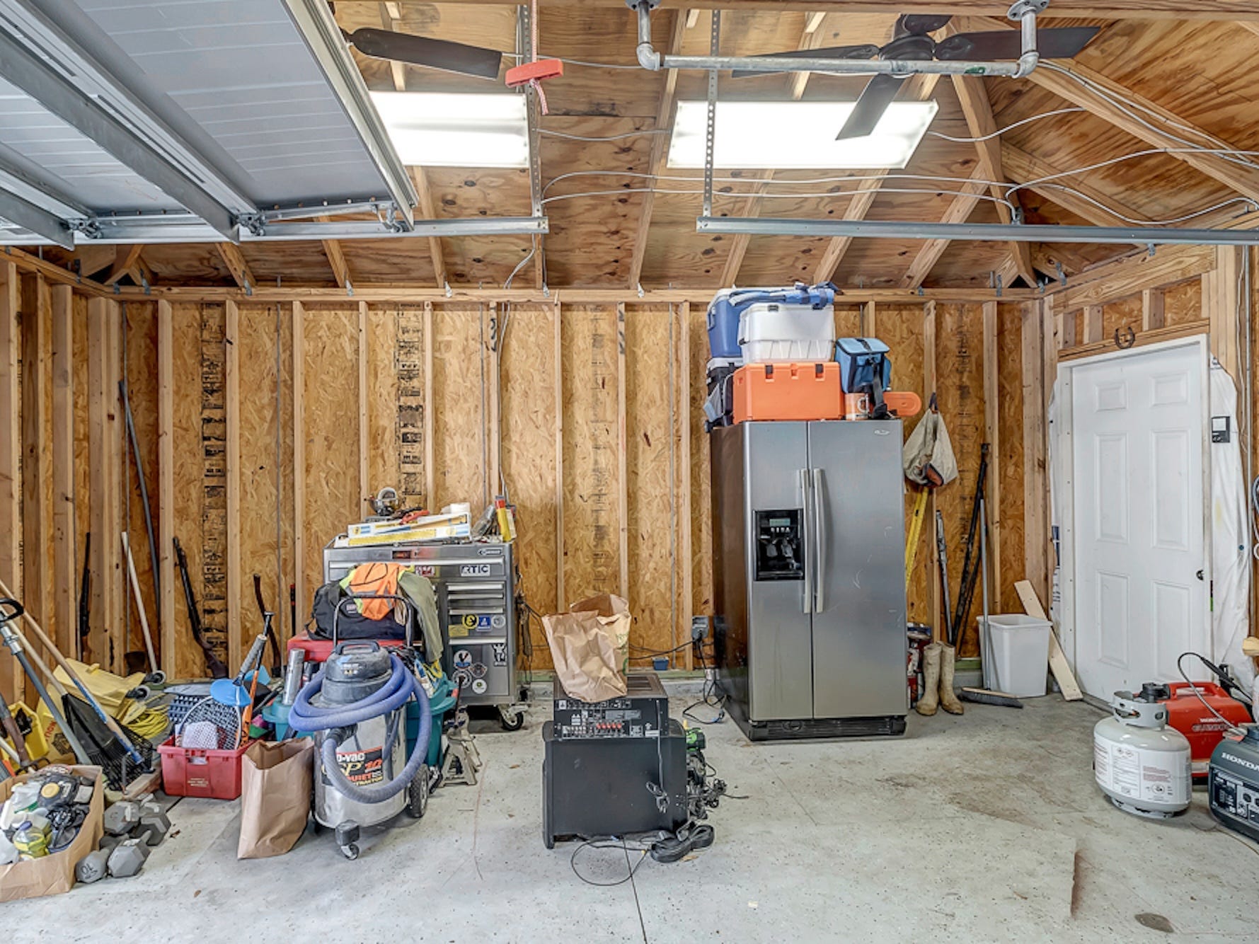 A photo of a garage with a refrigerator in it.