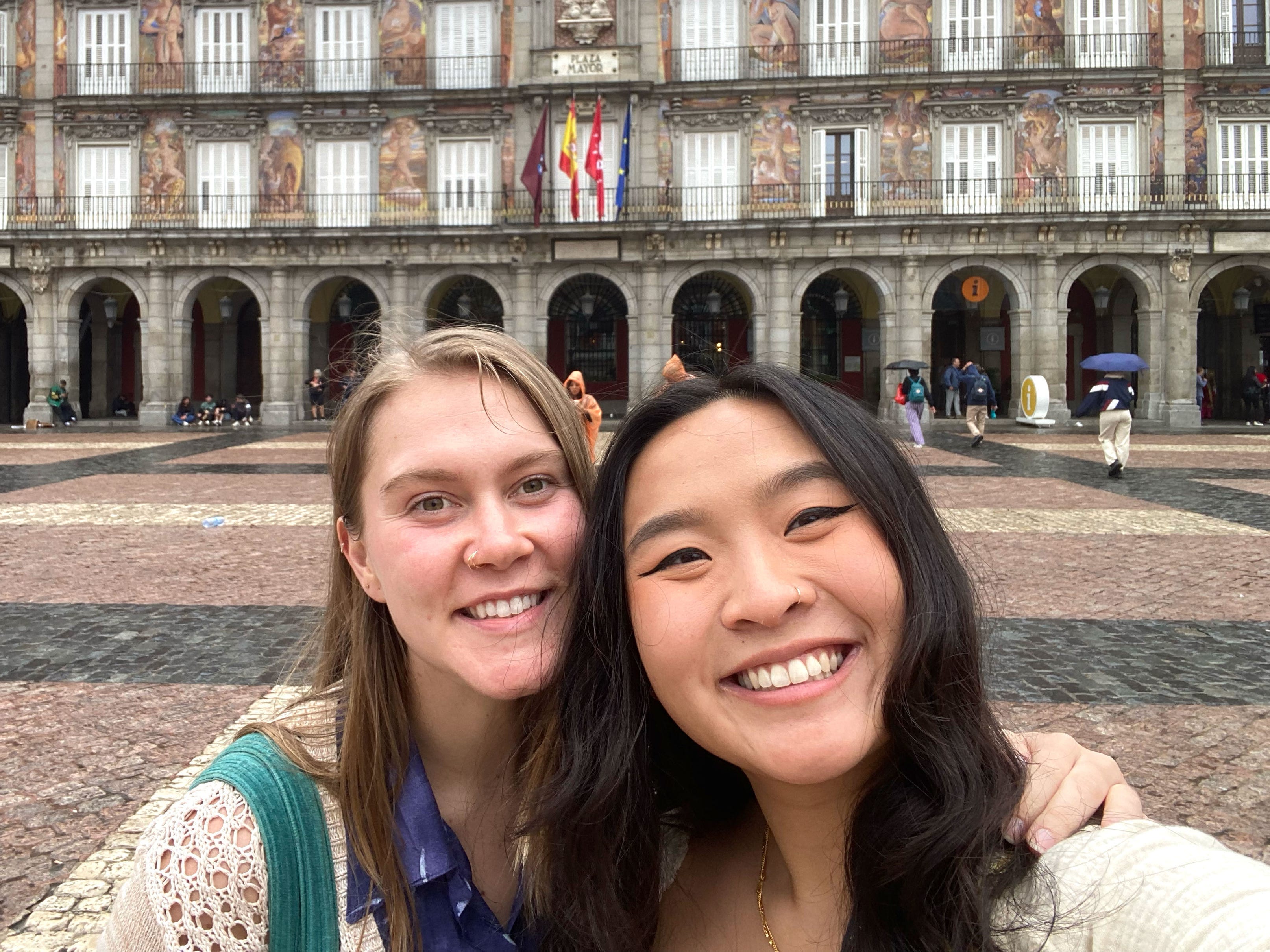 Christina and Megan pose in front of a four-story building in Madrid.