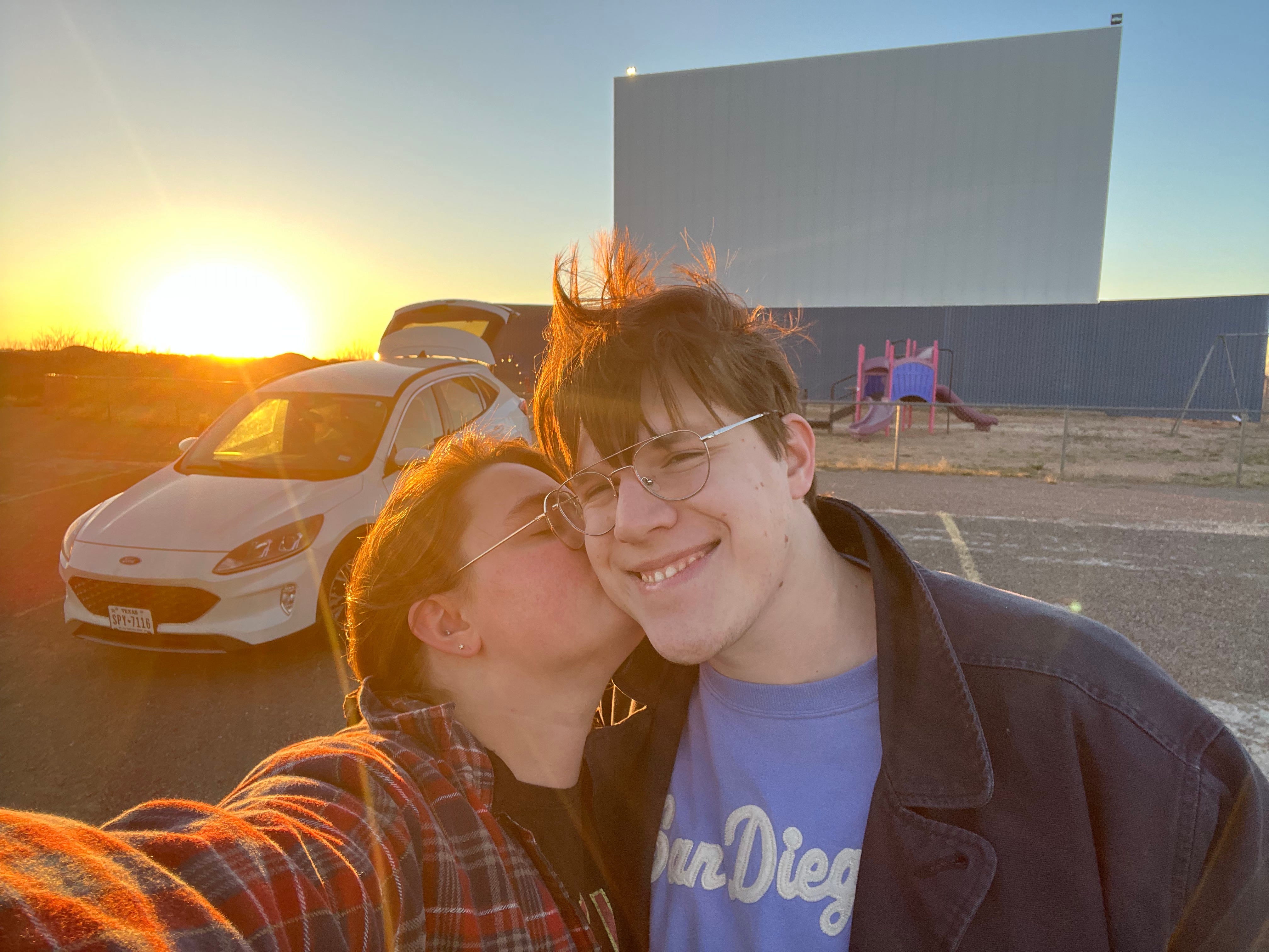 The author kissing her husband on the cheek at a drive-in movie theater.