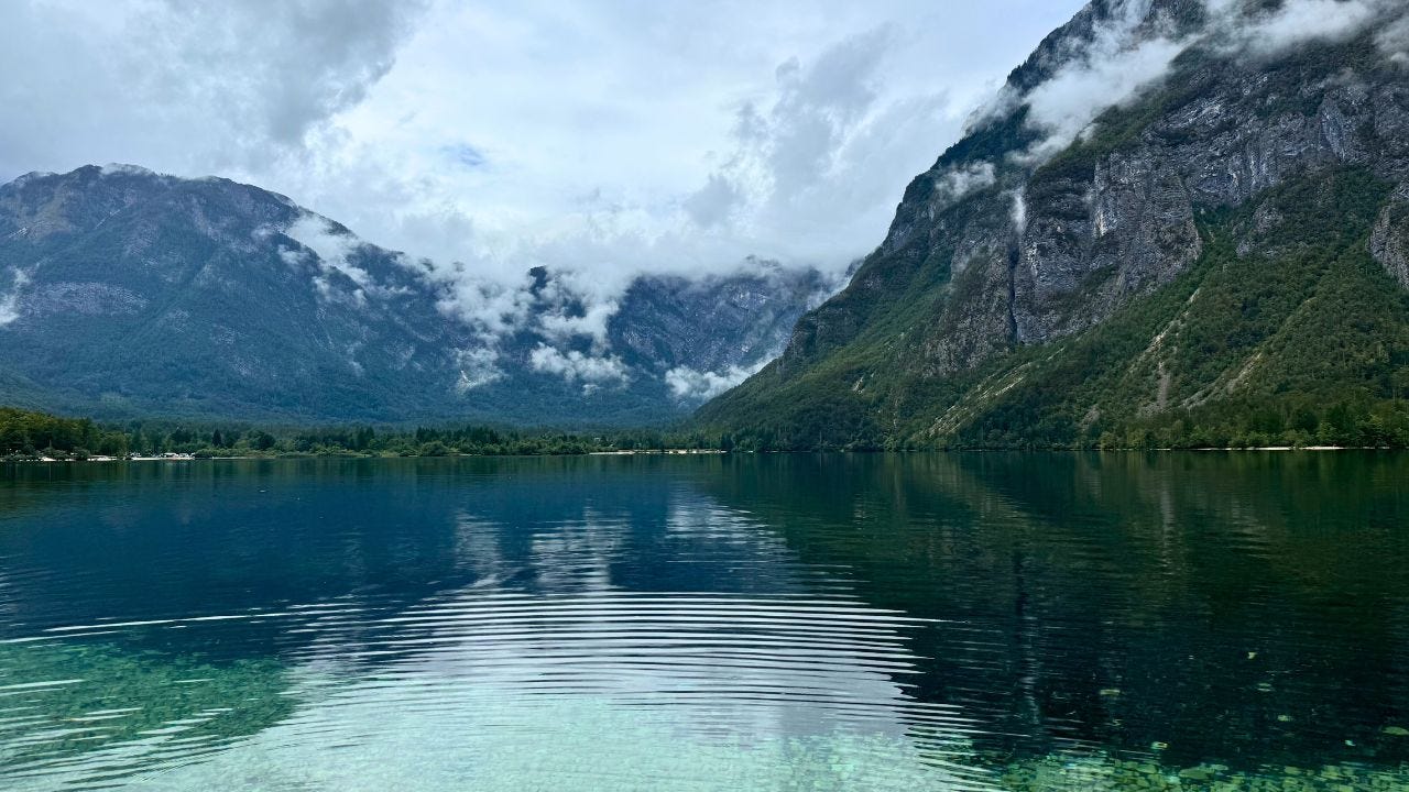 Blue waters on Lake Bohinj surrounded by mountains