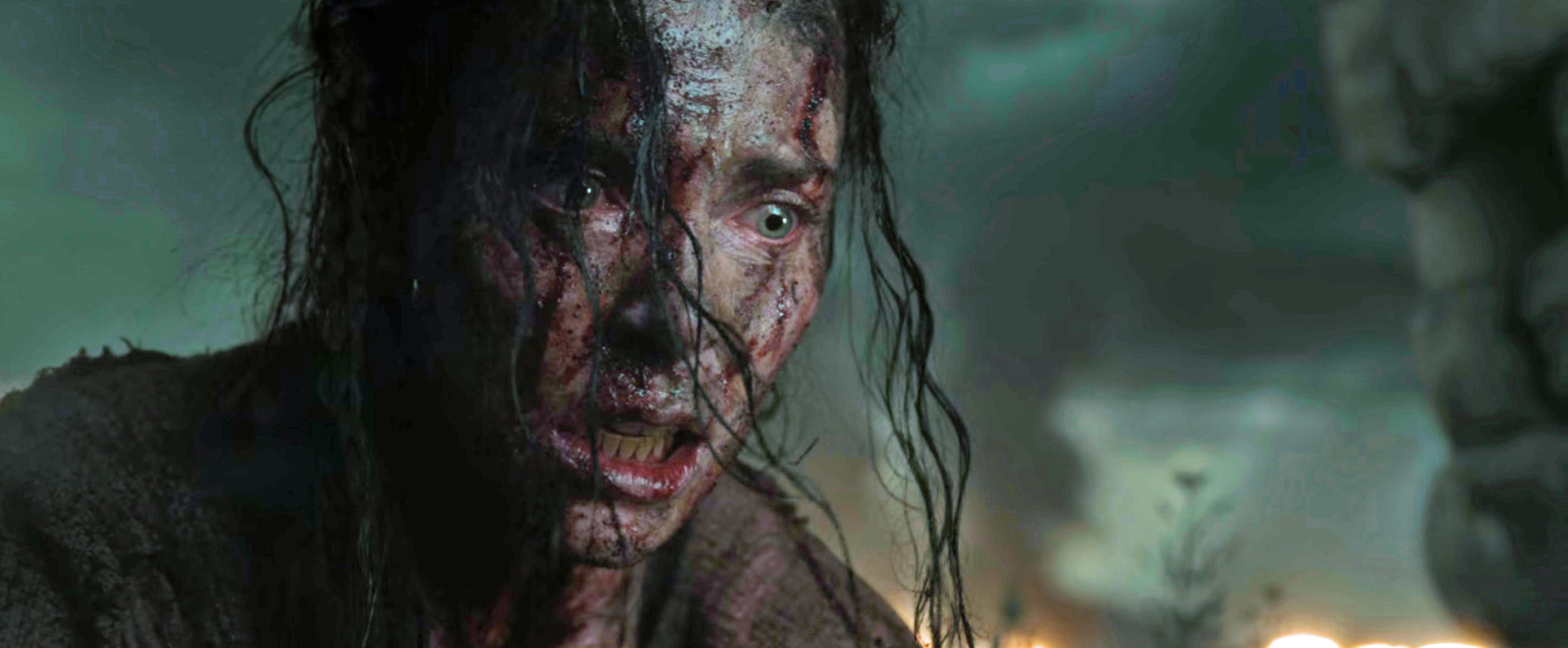 Charlize Theron covered in dirt and blood