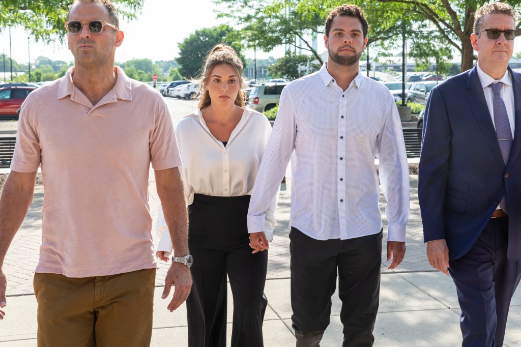 Christina Formella and her husband, along with another man and a lawyer, walking together.