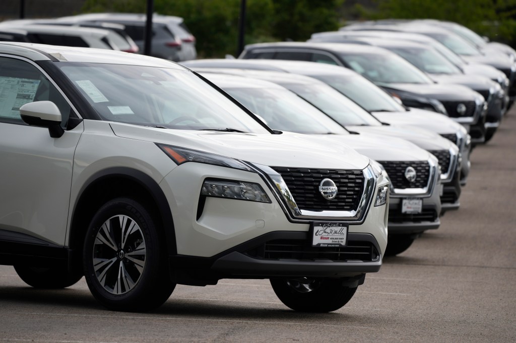 Row of unsold Nissan Rogue SUVs at a dealership.
