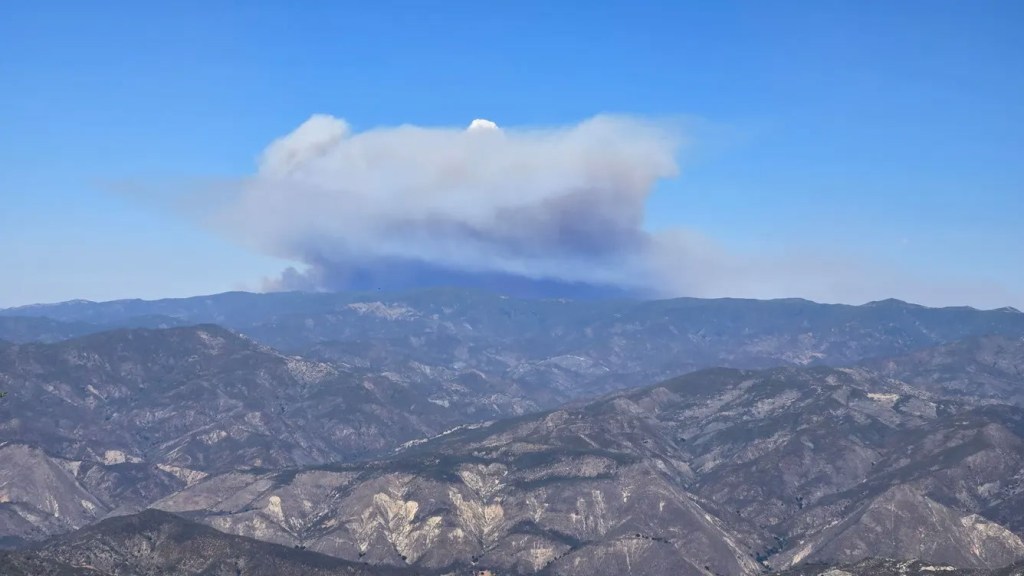 Smoke plume from the Madre Fire over a mountain range.