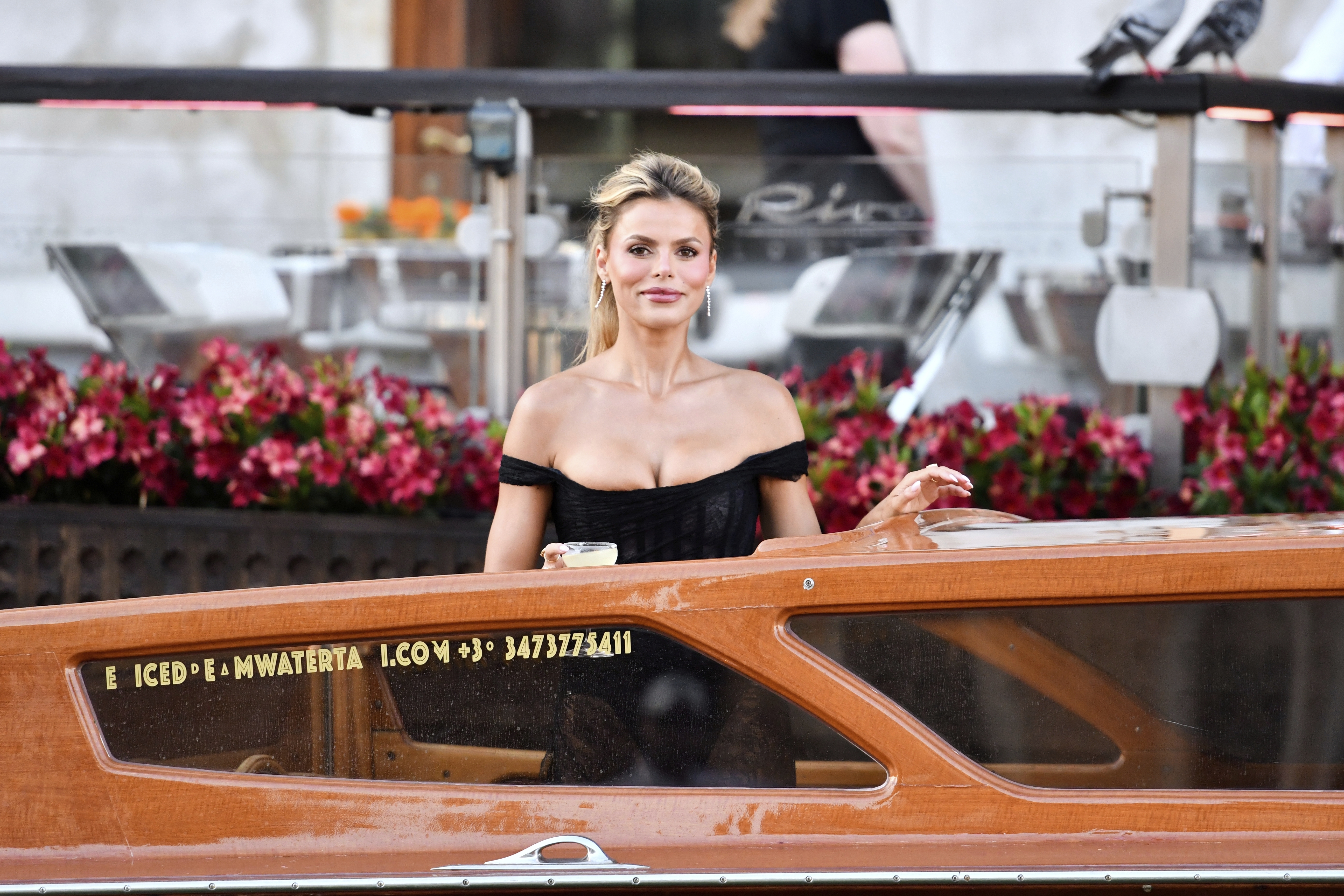 Brooks Nader in a black dress on a water taxi. 
