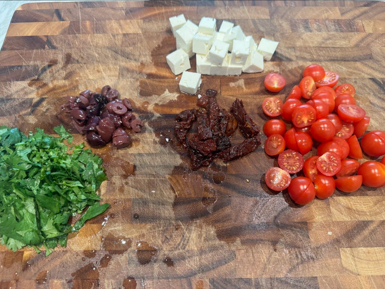 Chopped vegetables, mixings, and cheese for Ina Garten's summery pasta salad recipe.