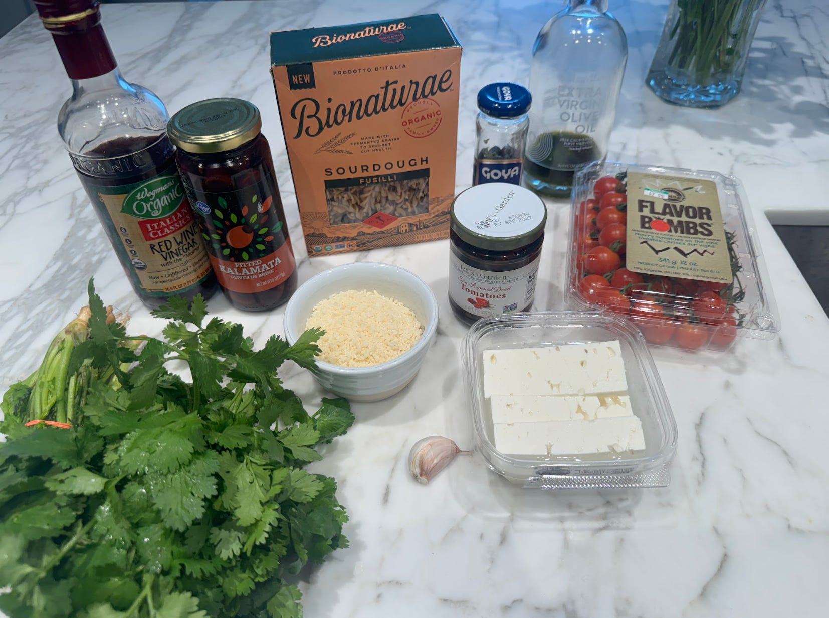 All the ingredients you'll need to make Ina Garten's pasta salad, including wine vinegar, fusilli, Parmesan, feta, and tomatoes.